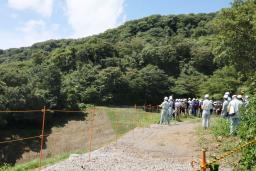 　公開された熱海大規模土石流の起点で説明を受ける被災者ら＝３１日午前、静岡県熱海市