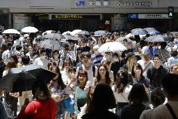 　猛暑の中、大阪・梅田を歩く人たち＝７月