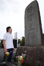 　「藤岡事件」の犠牲者の慰霊碑を見つめる小林里樹さん＝８月、群馬県藤岡市