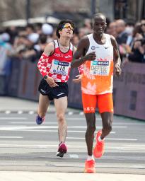 　男子の日本勢トップとなる１０位でゴールする市山翼（左）＝東京都千代田区