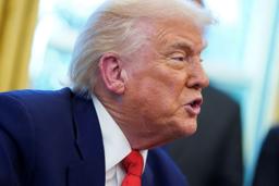　ホワイトハウスの執務室で大統領令にサインするトランプ米大統領＝９日、ワシントン（ロイター＝共同）