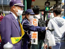 　事故現場近くで交通安全啓発のチラシなどを配る警察官＝１２日午後、京都市東山区