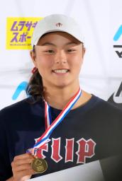 　女子ストリートで優勝し、金メダルを手に笑顔の松本雪聖＝三重県松阪市総合運動公園スケートパーク
