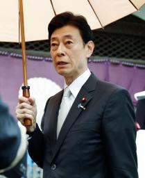 　靖国神社の参拝を終え、取材に応じる自民党の西村元経産相＝２３日午前、東京・九段北
