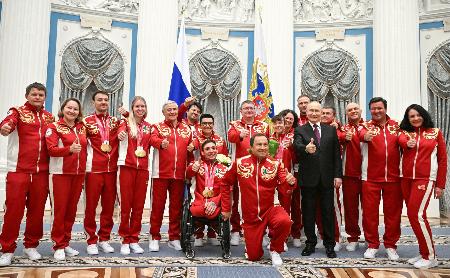 <p>　ミラノ・コルティナ冬季パラリンピックに出場したロシア選手らと写真に納まるプーチン大統領（右から５人目）＝１９日、モスクワ（ロシア大統領府提供・共同）</p>