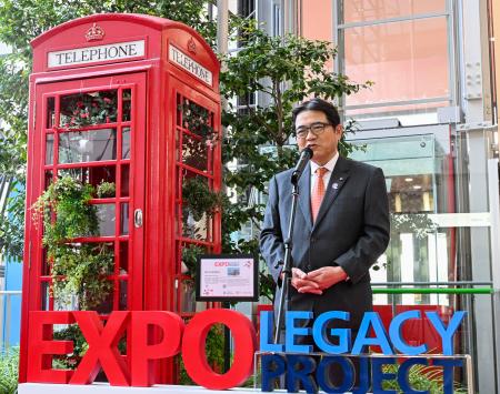 　大阪・関西万博の英国パビリオン前に設置されていた赤い「電話ボックス」前であいさつする関西エアポートの山谷佳之社長＝２７日午前、関西空港