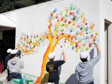 手形アートで体育倉庫カラフルに　勝浦・総野小　「ハッピーツリー」バルサミコヤスさんが下絵