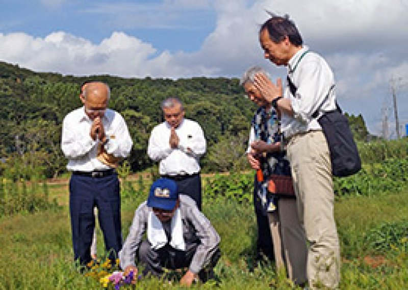 ゼロ戦墜落現場とみられる地点で合掌する栄作さん（左端）ら遺族や調査グループのメンバーら。当時の現場目撃者（中央手前）も同行した＝１５日、大多喜町