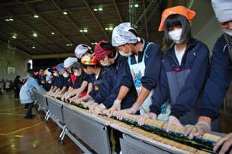息を合わせて太巻きずしを巻いていく生徒＝いすみ市岬町の岬中