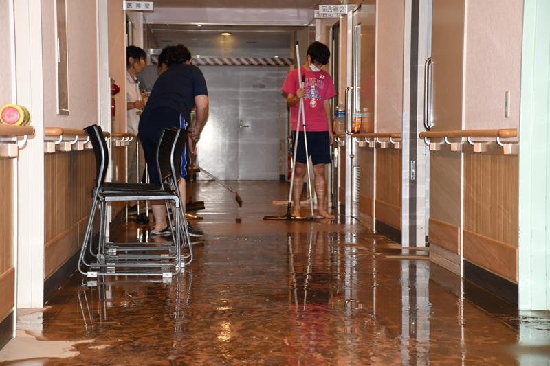 浸水した施設内で泥水の掃除に追われる職員ら＝２６日午後３時２０分、長柄町鴇谷