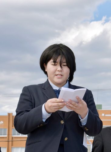 飯岡地区の海辺で作文を読み上げる篠塚さん＝１１日、旭市
