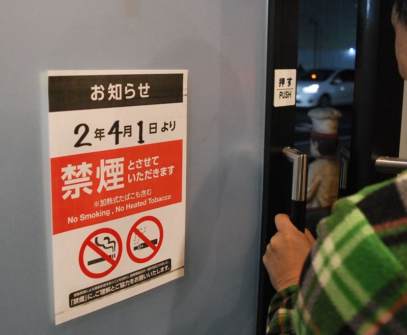出入り口に４月からの禁煙を伝える紙を掲示した飲食店＝千葉市中央区