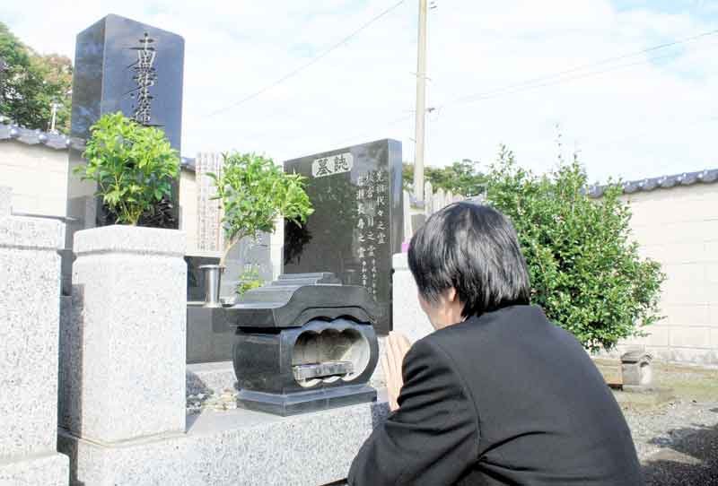 岩瀬長寿さんの墓前で手を合わせる長男の広光さん＝２５日、千葉市若葉区