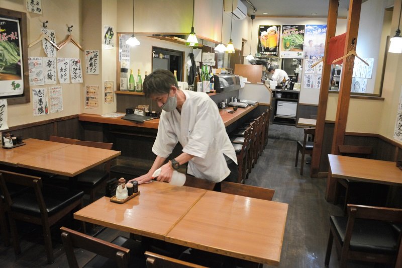 午後８時に早めた閉店を前に、客がいない店内を片付ける従業員＝８日夜、船橋市本町の居酒屋「一九」船橋南口本店