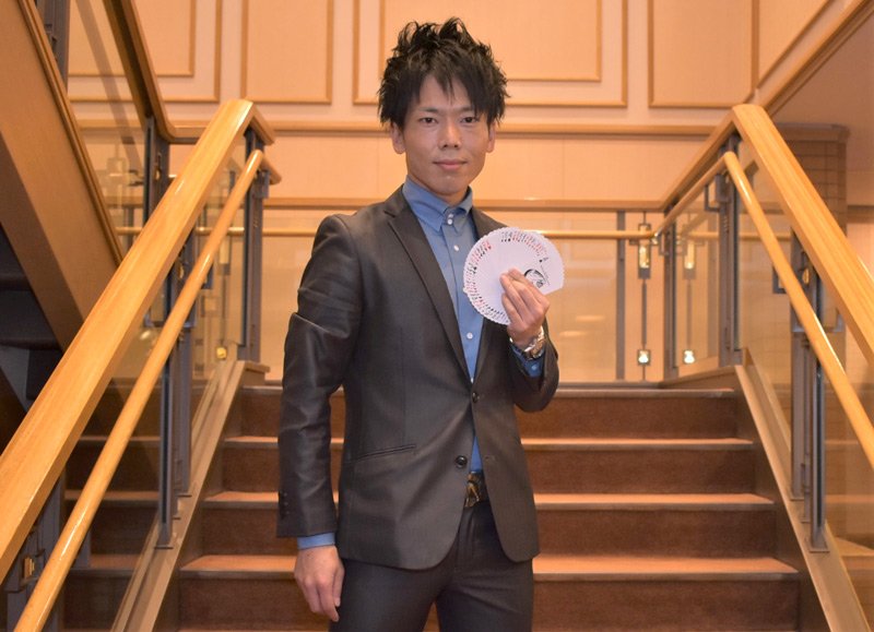 オリジナルトランプを手にする赤星賢志さん＝東京都千代田区