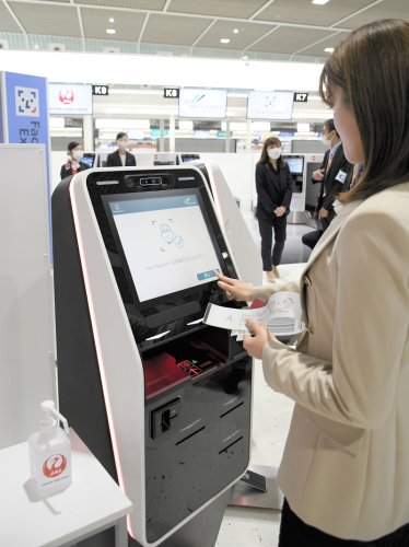 顔認証技術によって搭乗ゲートなどで搭乗券やパスポートの提示が必要なくなるシステムの実証実験がスタート。関係者が顔写真登録などのデモンストレーションを行った＝１３日、成田空港