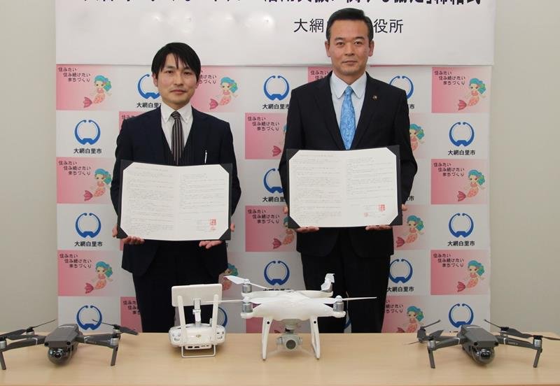 ドローン提供の協定を結んだ金坂市長（右）ら＝大網白里市
