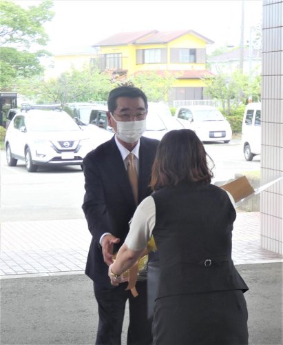 初登庁し職員から花束を受け取る石井町長＝２１日、白子町役場
