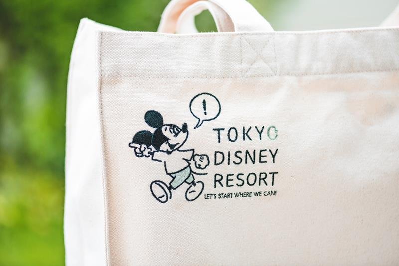「できることから始めよう」と書かれた英字がプリントされた、新商品のトートバック（（ｃ）Ｄｉｓｎｅｙ）
