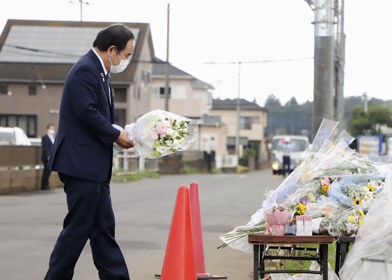 八街市の事故現場で花を手向ける坂本１億総活躍相＝９日午後（共同）
