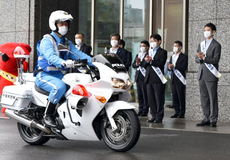 出動する警察隊員を見送る出席者ら＝９日午前９時１０分ごろ、県庁