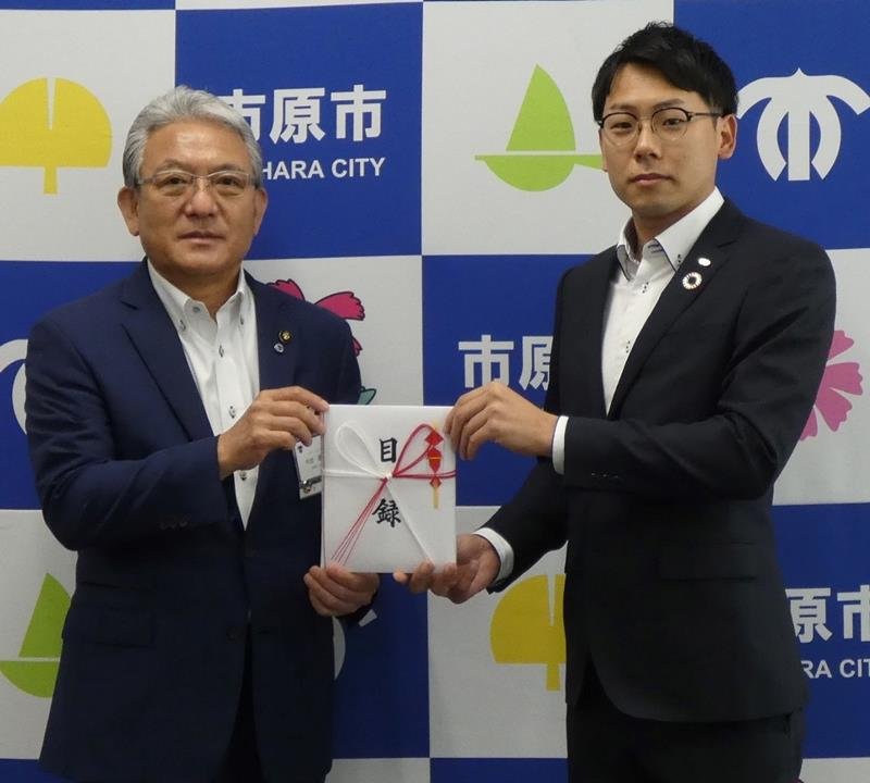 小出市長（左）に目録を手渡す千葉昭和サービスの長谷川社長（京葉銀行提供）