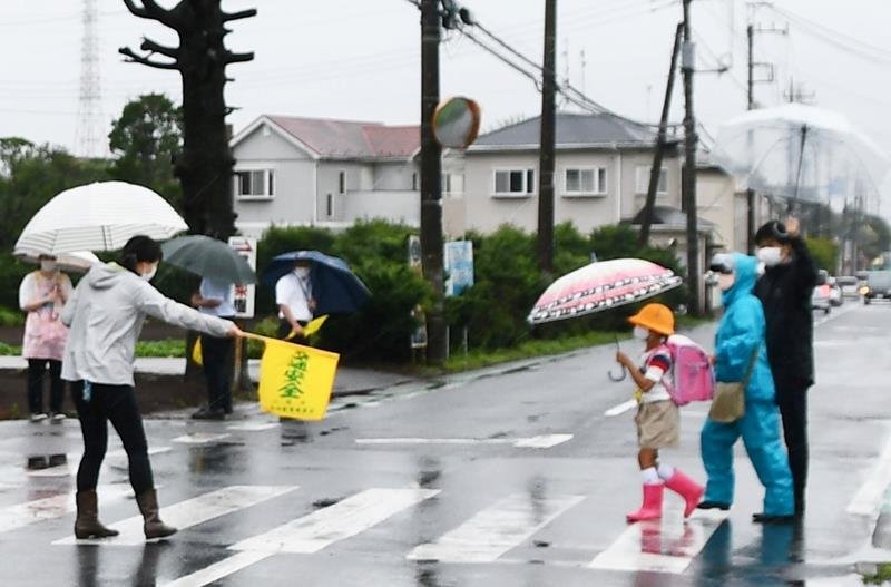 八街市で児童５人が死傷した事故の翌日に交差点で見守り活動をする学校職員ら＝６月２９日朝、同市
