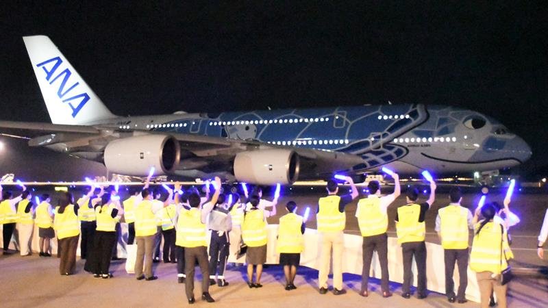 青いペンライトを振るスタッフに見送られ、滑走路に向かうフライングホヌ＝９日夜、成田空港