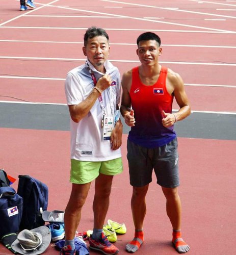ラオス代表のケン・テプティダ（右）と写真に納まる羽根裕之さん＝２８日、国立競技場（羽根さん提供、共同）
