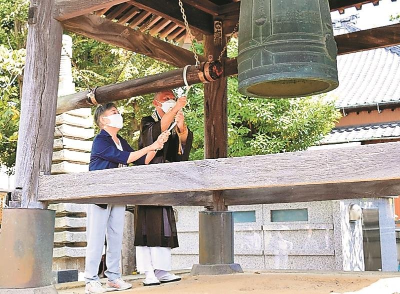 住職とともに「平和の鐘」を突く宇田川さん（左）＝２１日、浦安市