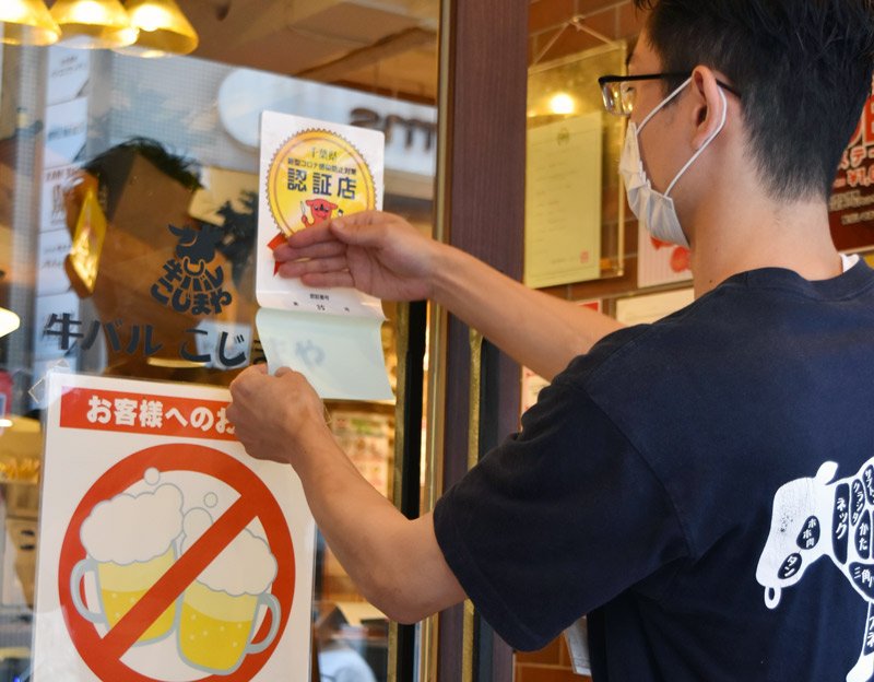 認証店のステッカーを貼る「牛バル　こじまや　千葉店」の店員＝２８日午後１時４０分ごろ、千葉市中央区