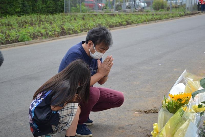 児童５人が死傷した八街市の事故現場で手を合わせる親子＝６月２９日午後、八街市（吉田記者撮影）
