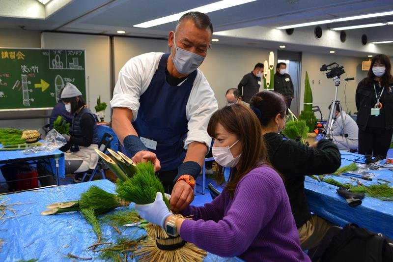 植木業者の指導を受け、ミニ門松作りに取り組む参加者ら＝２５日、千葉市中央区の県文化会館
