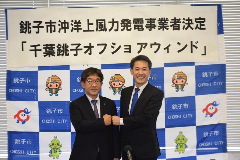 会見で写真撮影に応じる越川市長（左）と三菱商事エナジーソリューションズの岩崎社長＝２８日、銚子市役所
