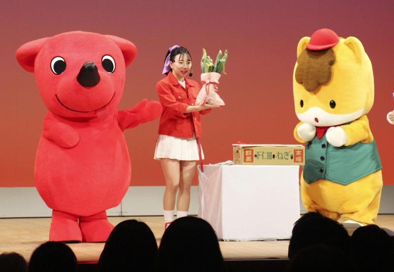 チーバくん（左）に、群馬県名産の下仁田ネギをプレゼントするぐんまちゃん（右）＝９日午後、浦安市文化会館（共同）