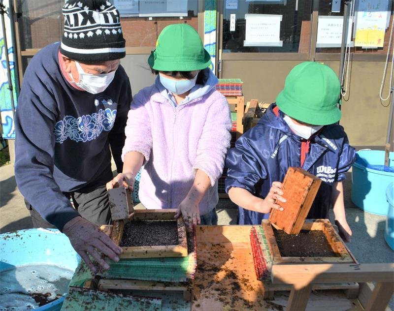 漁師らに教わり、升や木枠を使った伝統のノリすきに挑戦する児童たち＝１月１８日、船橋市の船橋漁港
