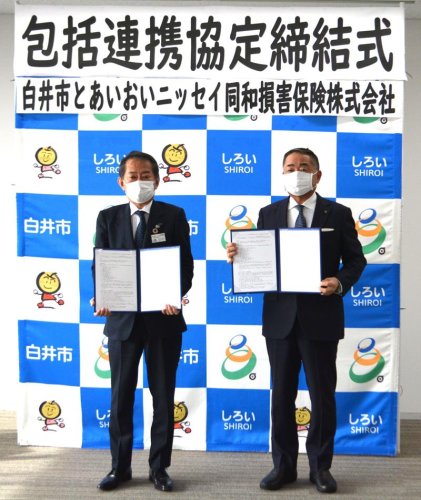 協定書を交わした笠井市長（右）と田中理事＝白井市役所