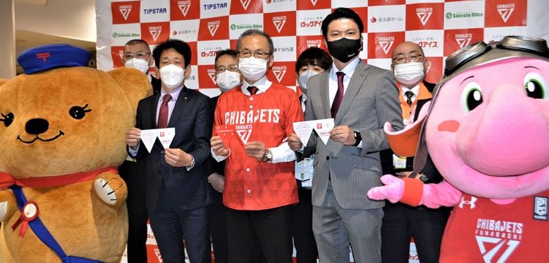 地元関係者らと一緒にジェッツ切手を披露する田村社長（前列右）＝船橋市の船橋アリーナ