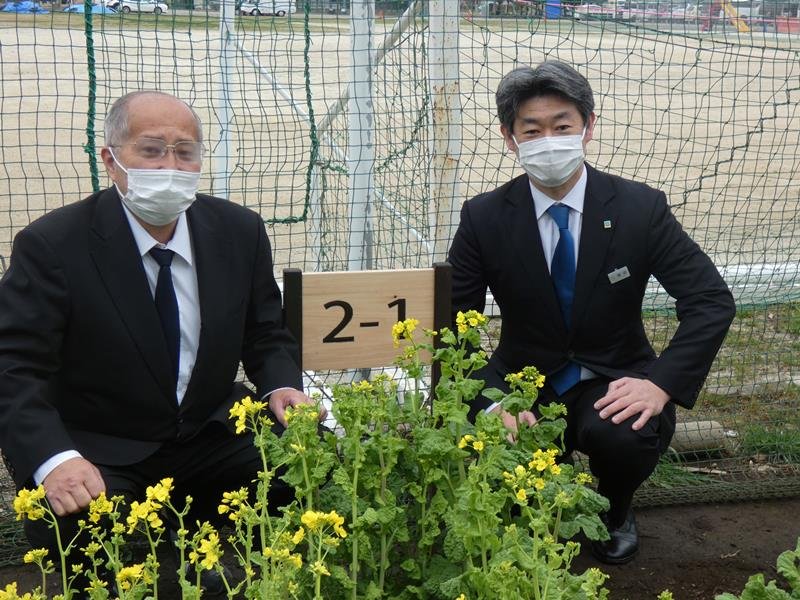 花壇の表示札など木製品を寄贈した窪田副支店長（右）。左は増田校長＝茂原市立本納小

