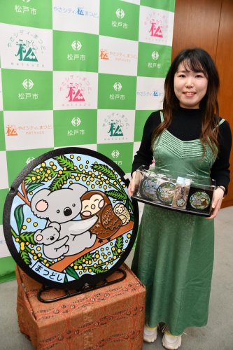 新デザインのカラー版マンホールとデザインが採用された武井さん＝松戸市
