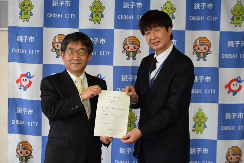 越川市長（左）から協力隊の委嘱状を受け取る榊さん
