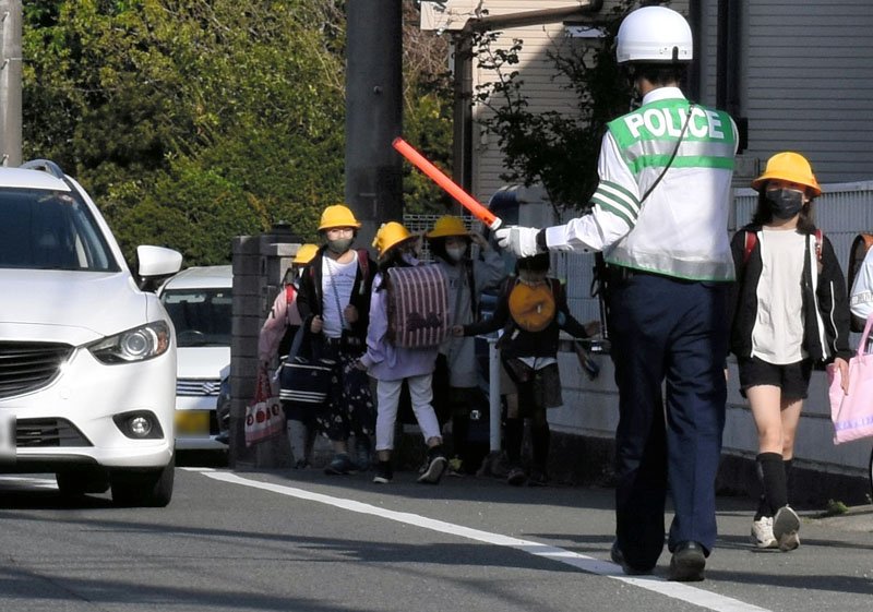 児童の登校時間帯に車両通行止めとなる市道で取り締まりをする千葉南署員ら＝１２日、千葉市緑区（画像の一部を加工しています）