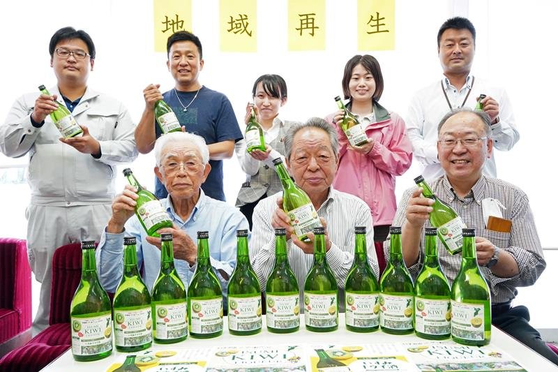 いすみキウイ酒を持つプロジェクト関係者＝いすみ市

