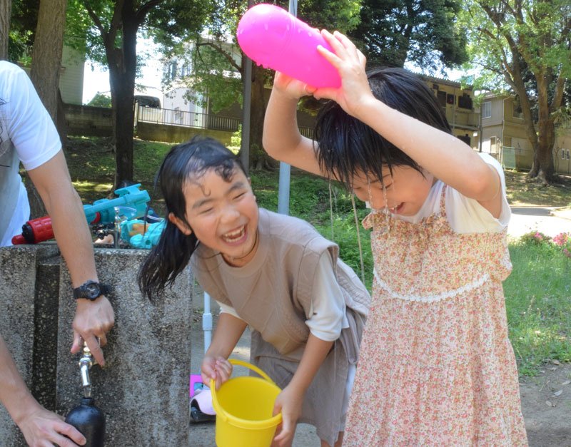 水を頭からかぶり、暑さをしのぐ子ども＝２９日午前１１時半ごろ、千葉市中央区の千葉公園
