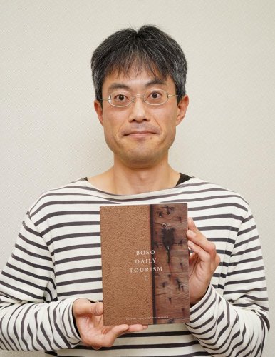 著書「ＢＯＳＯ　ＤＡＩＬＹ　ＴＯＵＲＩＳＭ　II」を手にする沼尻さん
