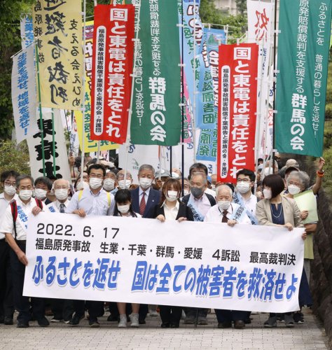 東京電力福島第１原発事故で避難した住民らが国に損害賠償を求めた集団訴訟の上告審判決で、最高裁に向かう原告ら＝１７日午後、東京都千代田区（共同）