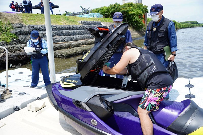 水上バイク利用者に声を掛ける警察や海保職員＝１８日、いすみ市の夷隅川河口
