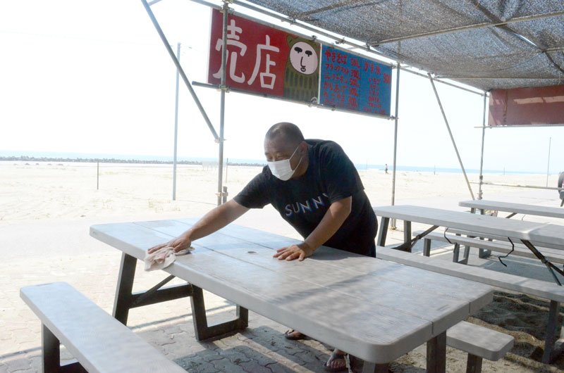 「海の家九十九里館」で開店準備を行う店長の幸地泰政さん＝１日、九十九里町の片貝海水浴場