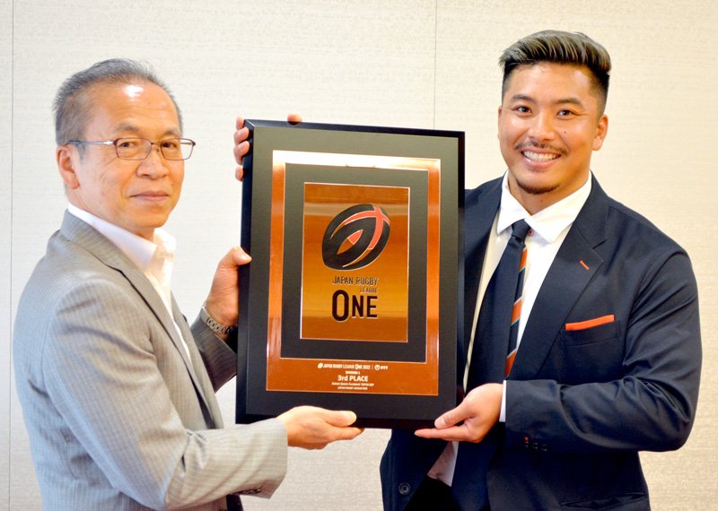ラグビー「リーグワン」３位の盾を披露し、来季の優勝に向け意気込みを示したクボタスピアーズ船橋・東京ベイの末永選手（右）。左は松戸市長＝船橋市役所