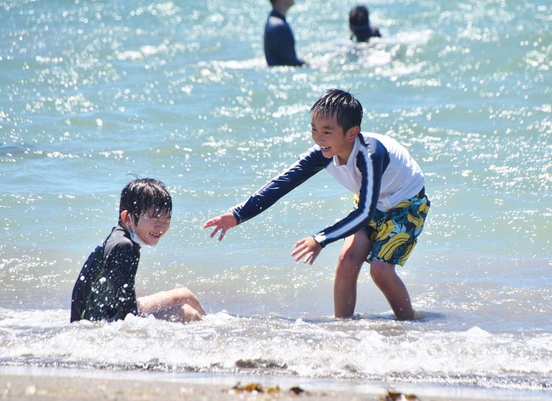 青空の下、波打ち際ではしゃぐ子どもたち＝２３日、館山市の沖ノ島海水浴場